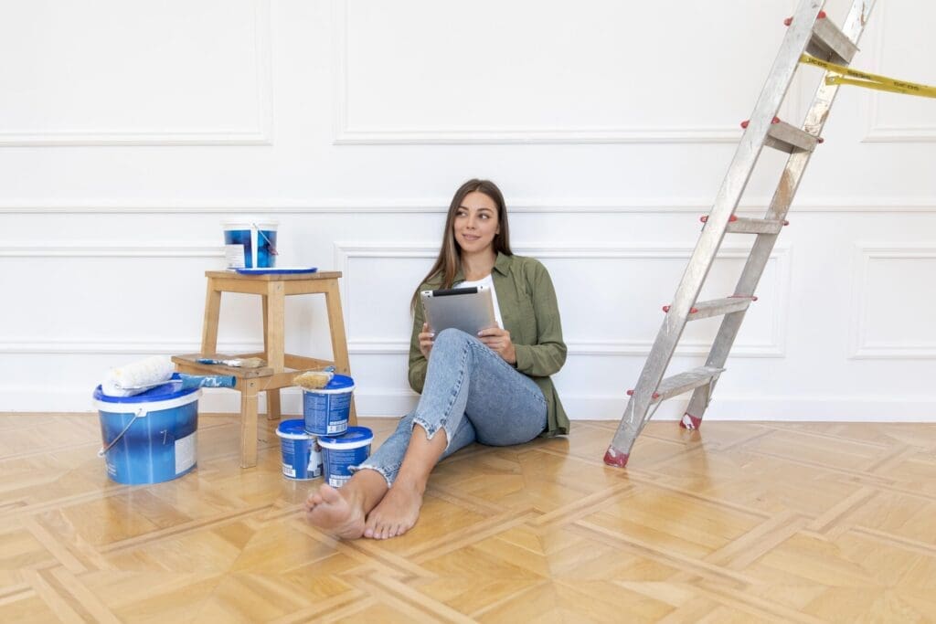 full shot woman floor holding tablet 2