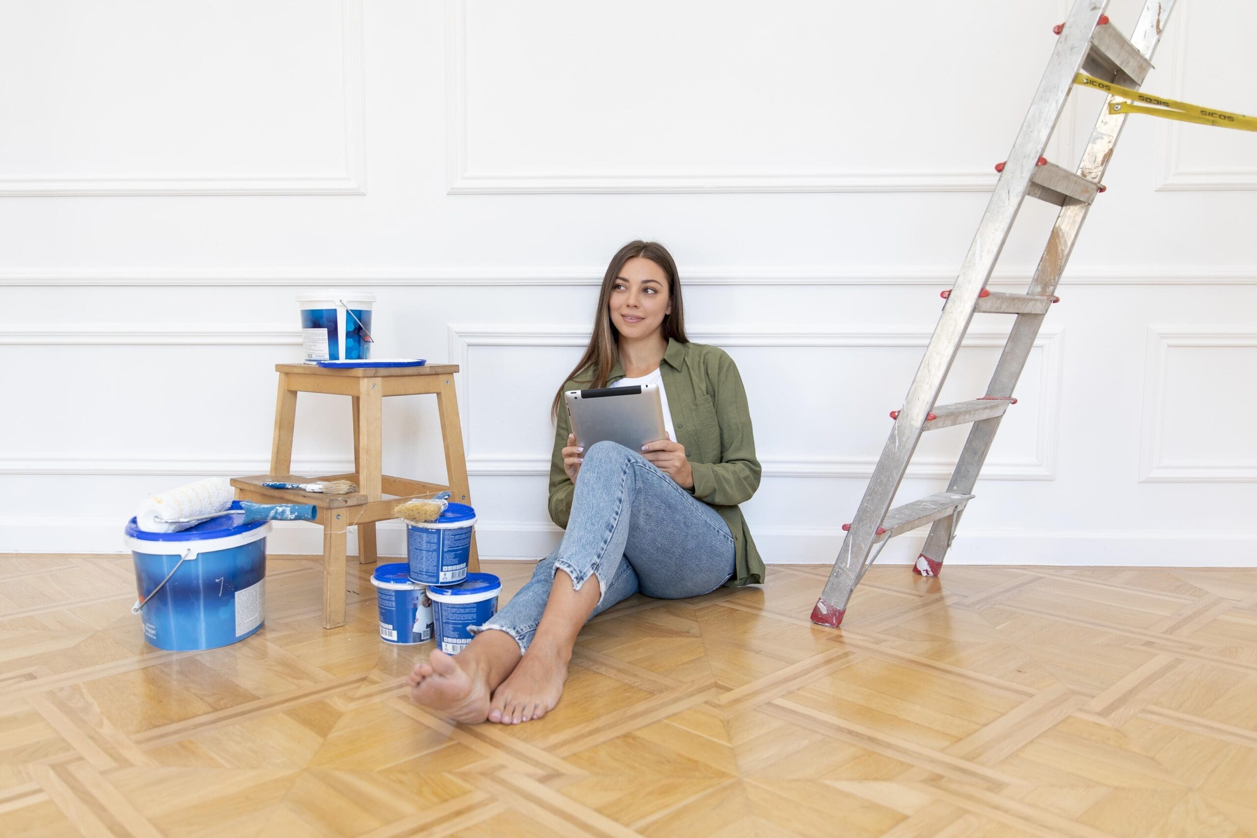 full shot woman floor holding tablet 2
